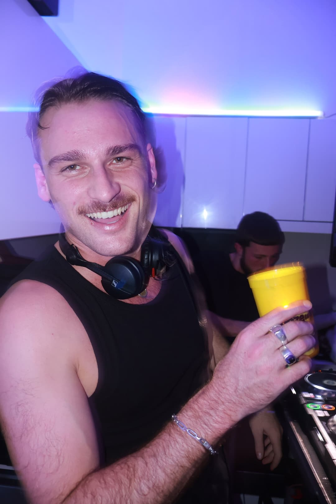 Cup in hand behind the decks