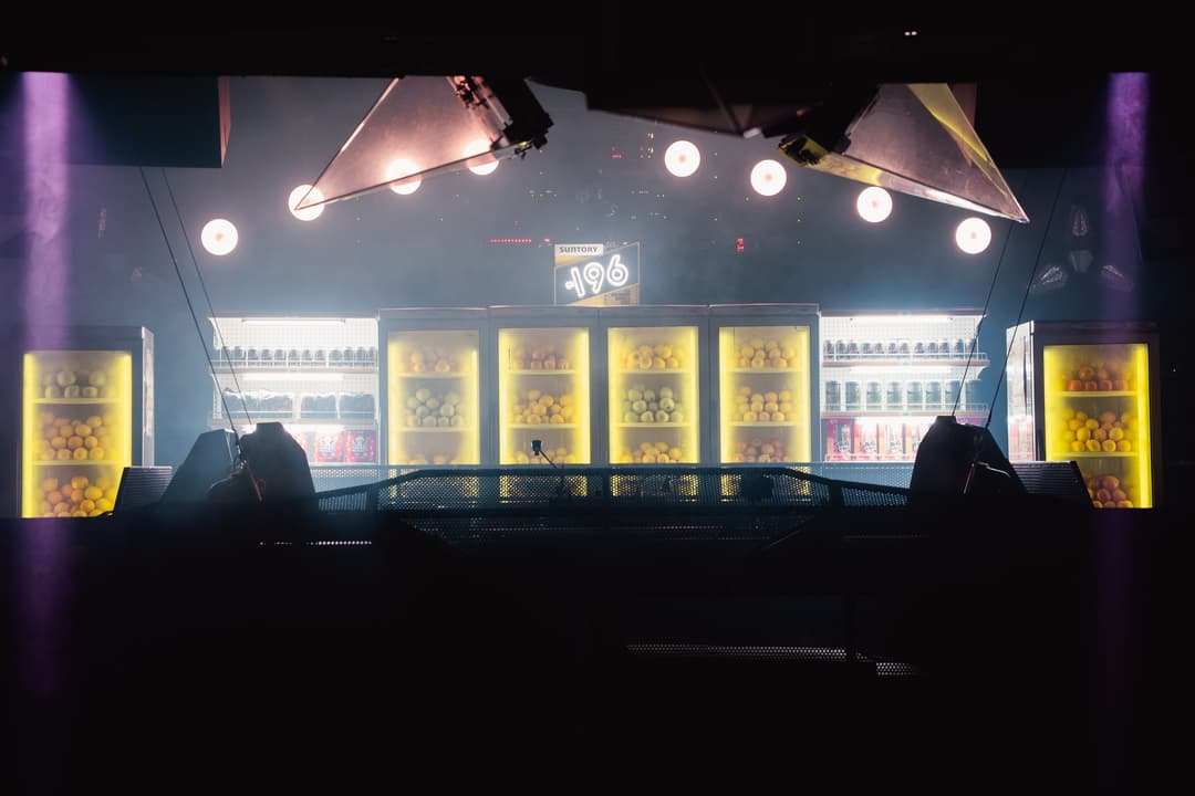 The konbini stage: a wall of lit -196 fridges behind the DJ booth at Carousel