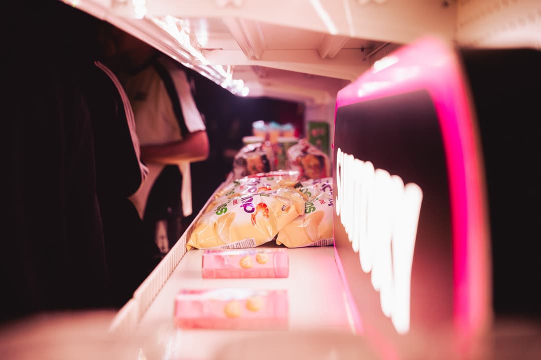 The bar counter lined with -196 cans under pink light