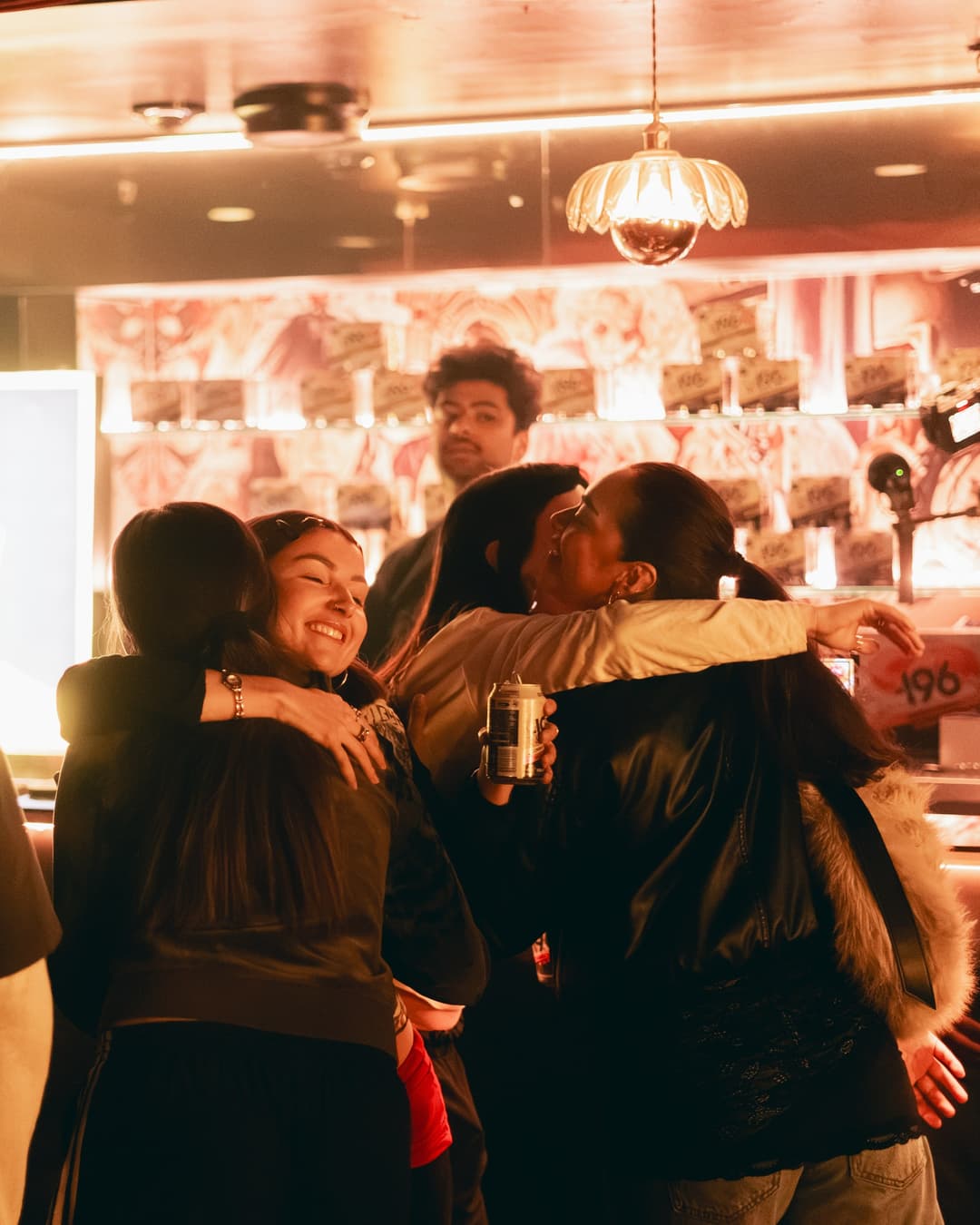 Friends hugging in front of the stocked shelves
